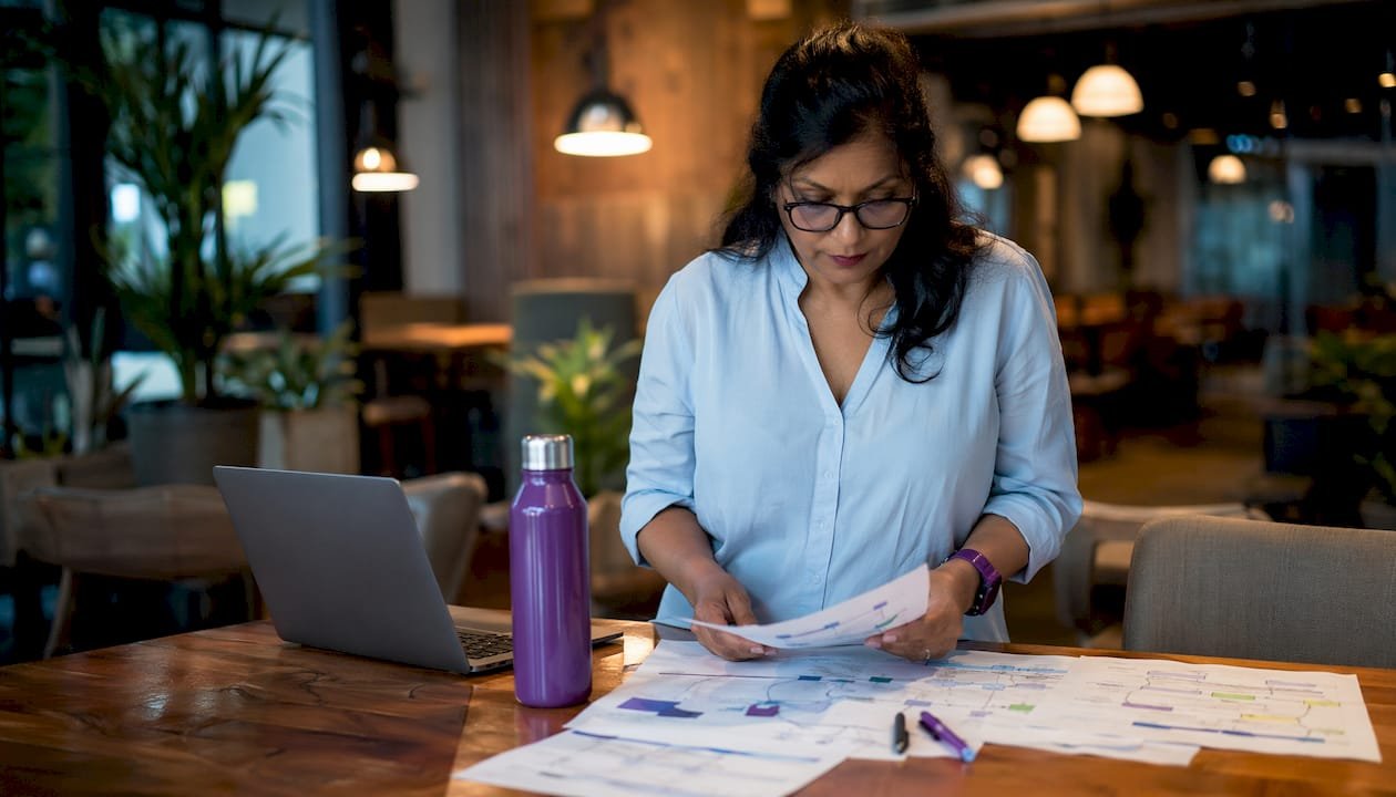Woman reviewing business workflow documents in office